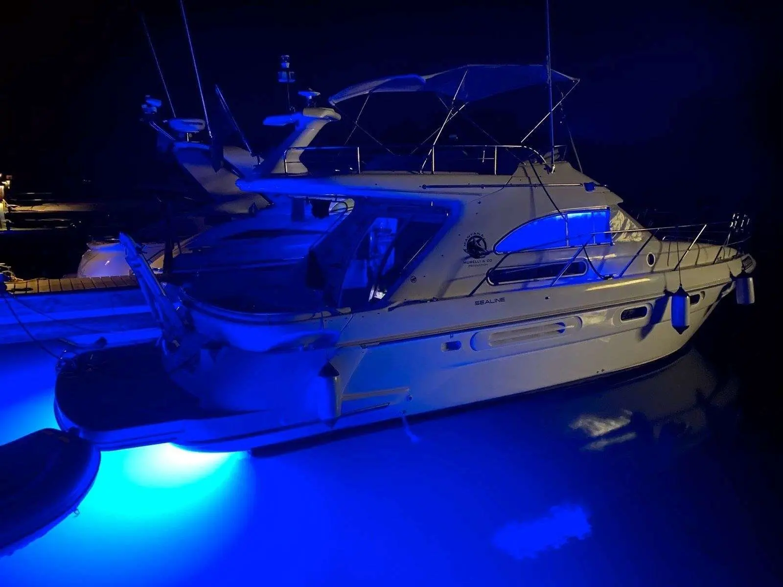 Sealine 360 — Bateau à moteur amarré de nuit, photographié de trois quarts arrière.