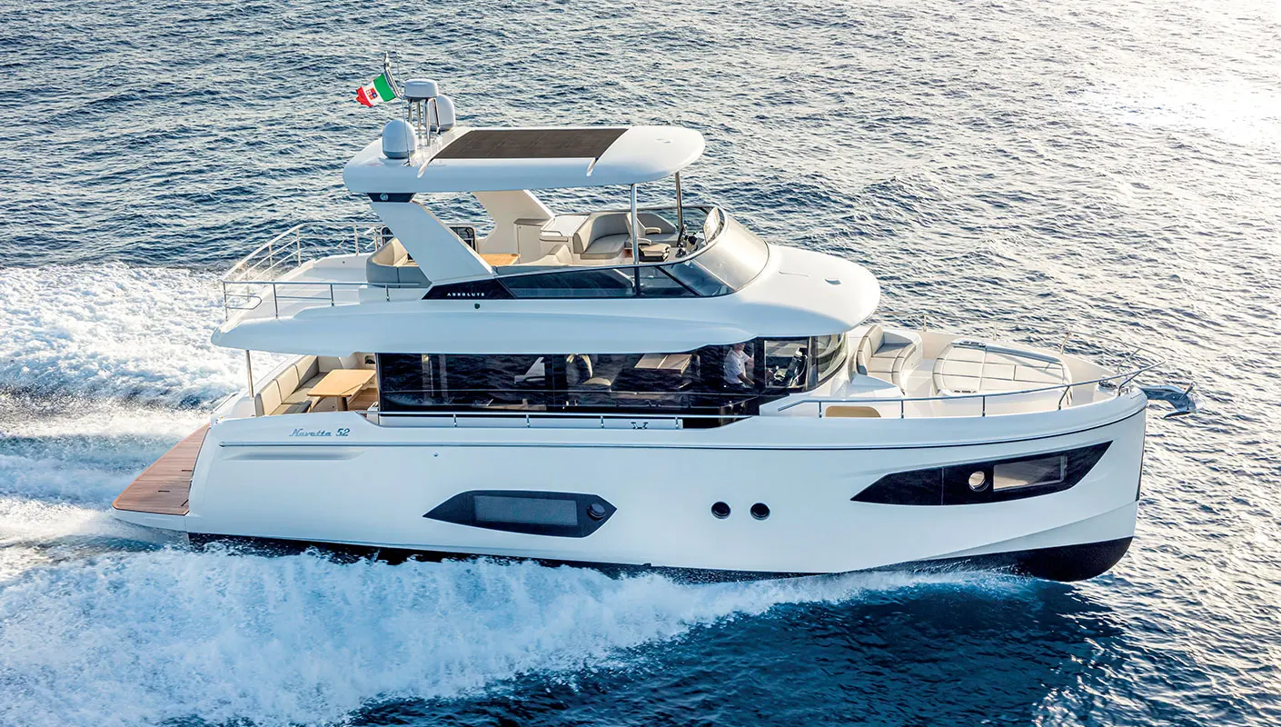 Absolute Navetta 52 — Bateau à moteur blanc vu de trois quarts, naviguant sur une mer agitée.