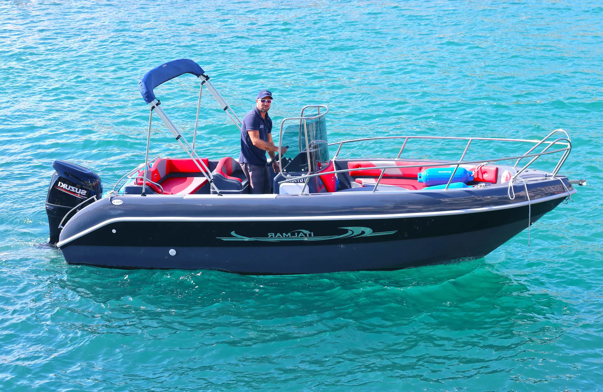 Italmar Open 20 — Bateau à moteur noir et rouge vu de profil sur une eau turquoise.