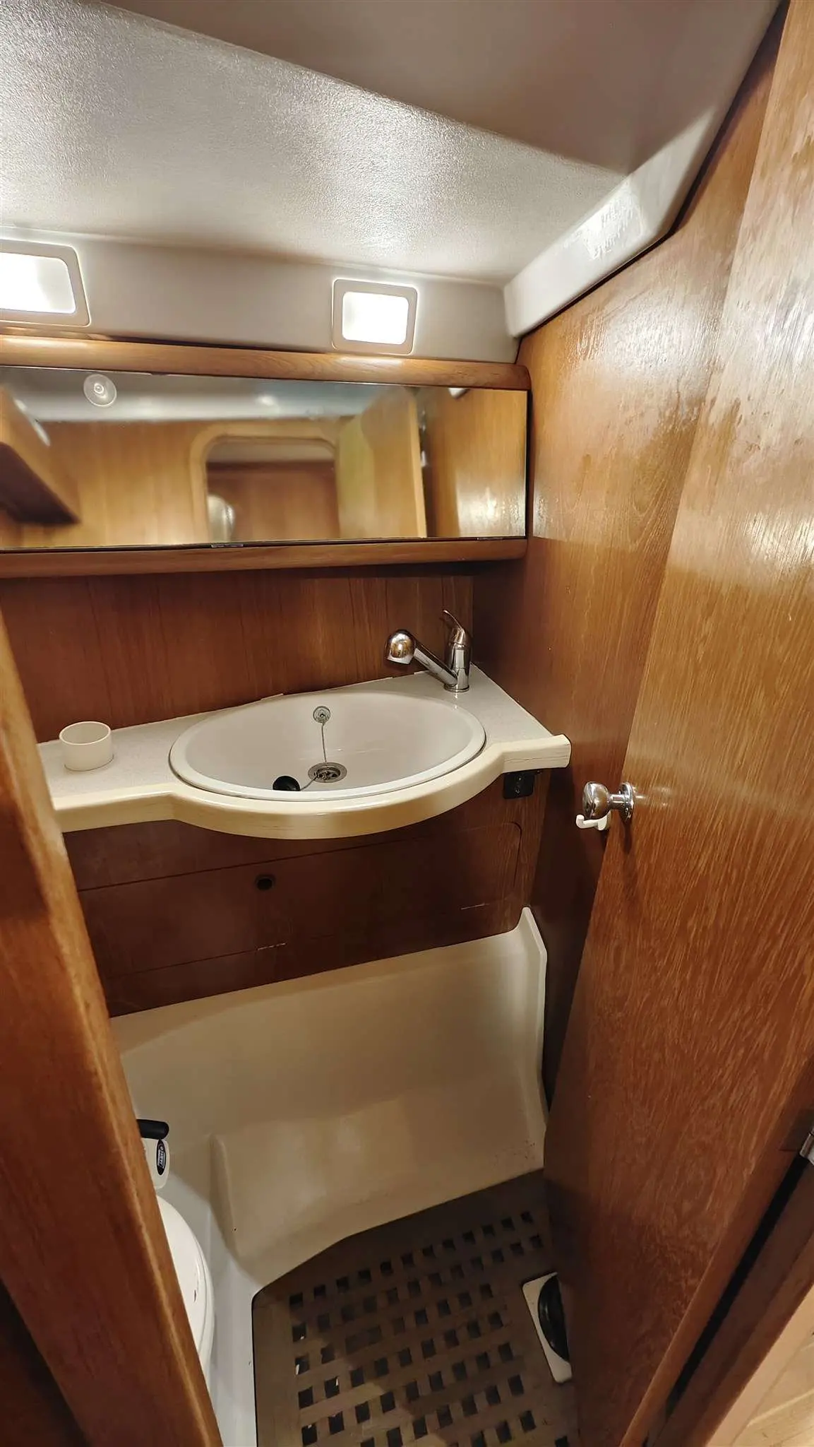 Grand Soleil 45 — Salle d’eau intérieure avec lavabo, miroir et cabine de douche en bois.