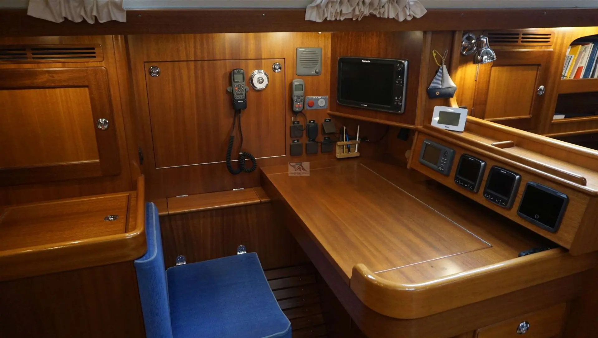 Hallberg Rassy 48 — Table à cartes intérieure avec instruments de navigation et équipements radio.