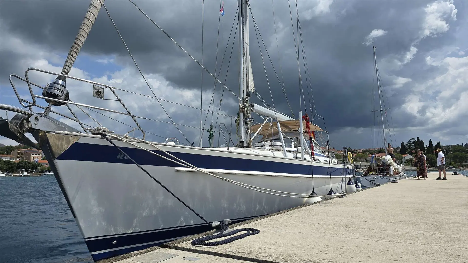 Hallberg Rassy 48 — Voilier amarré le long d’un quai, photographié par l’avant bâbord.