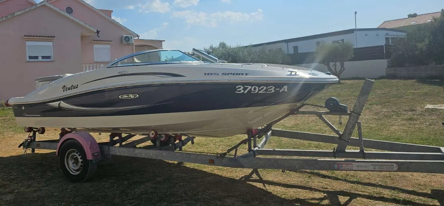 Sea Ray 185 Sport — Bateau à moteur de plaisance sur remorque, photographié de profil.