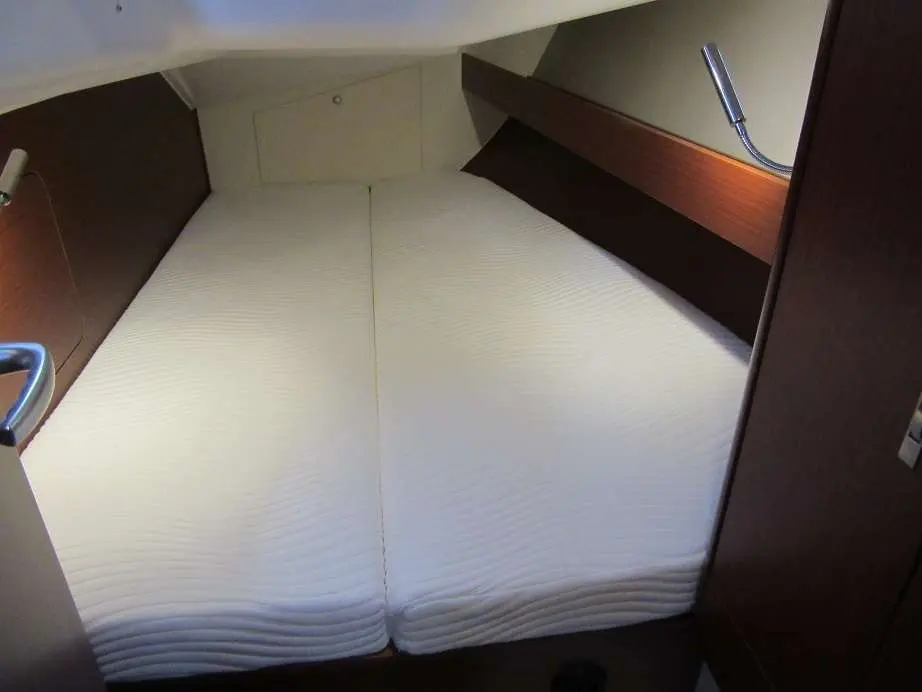 Dehler 38 — Couchette double avec matelas blancs et rangements intégrés.