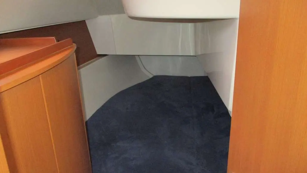 Hanse 325 — Vue partielle d'une couchette intérieure entre des rangements en bois.