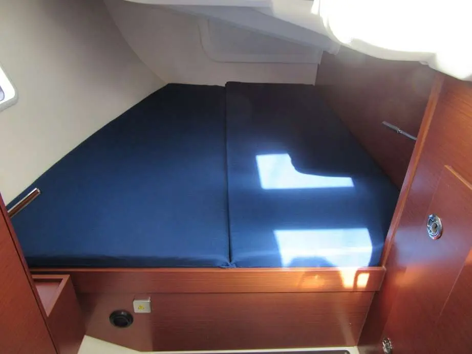 Hanse 418 — Couchette double avec matelas bleu dans une cabine à bord du bateau.