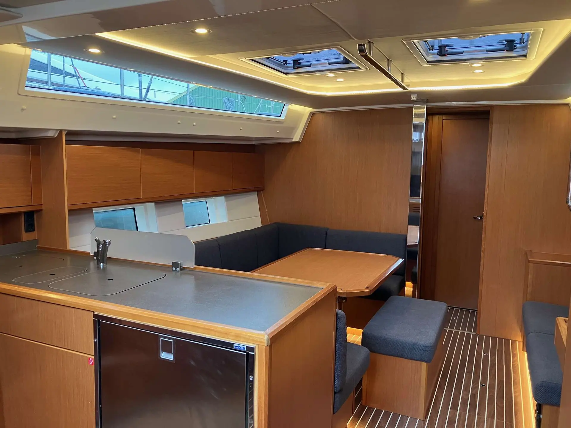 Bavaria Cruiser 45 — Vue intérieure sur la cuisine et le salon d’un bateau.