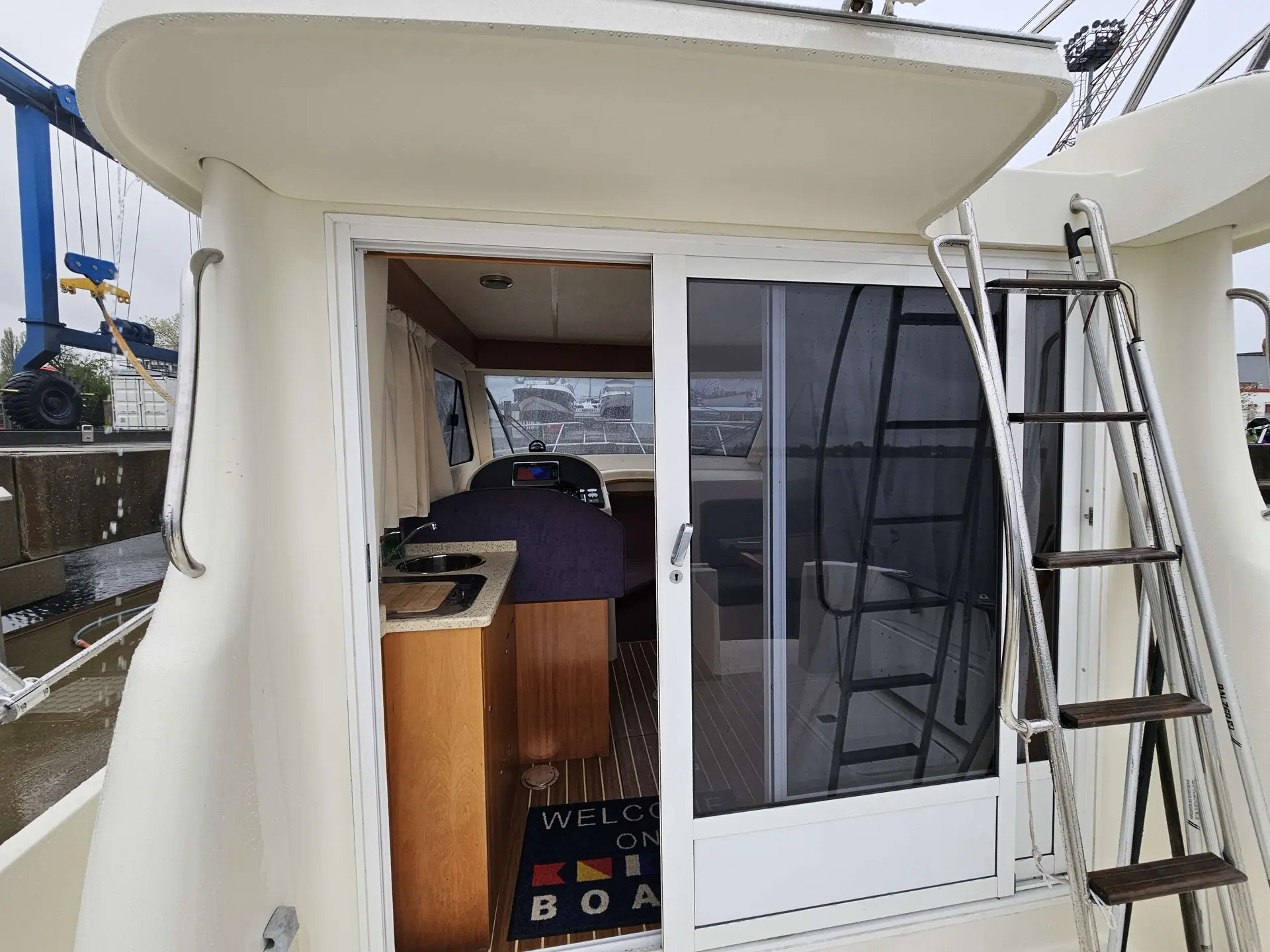 Rodman 940 — Vue arrière d’un bateau montrant l’accès à la cabine, le poste de pilotage et une échelle.
