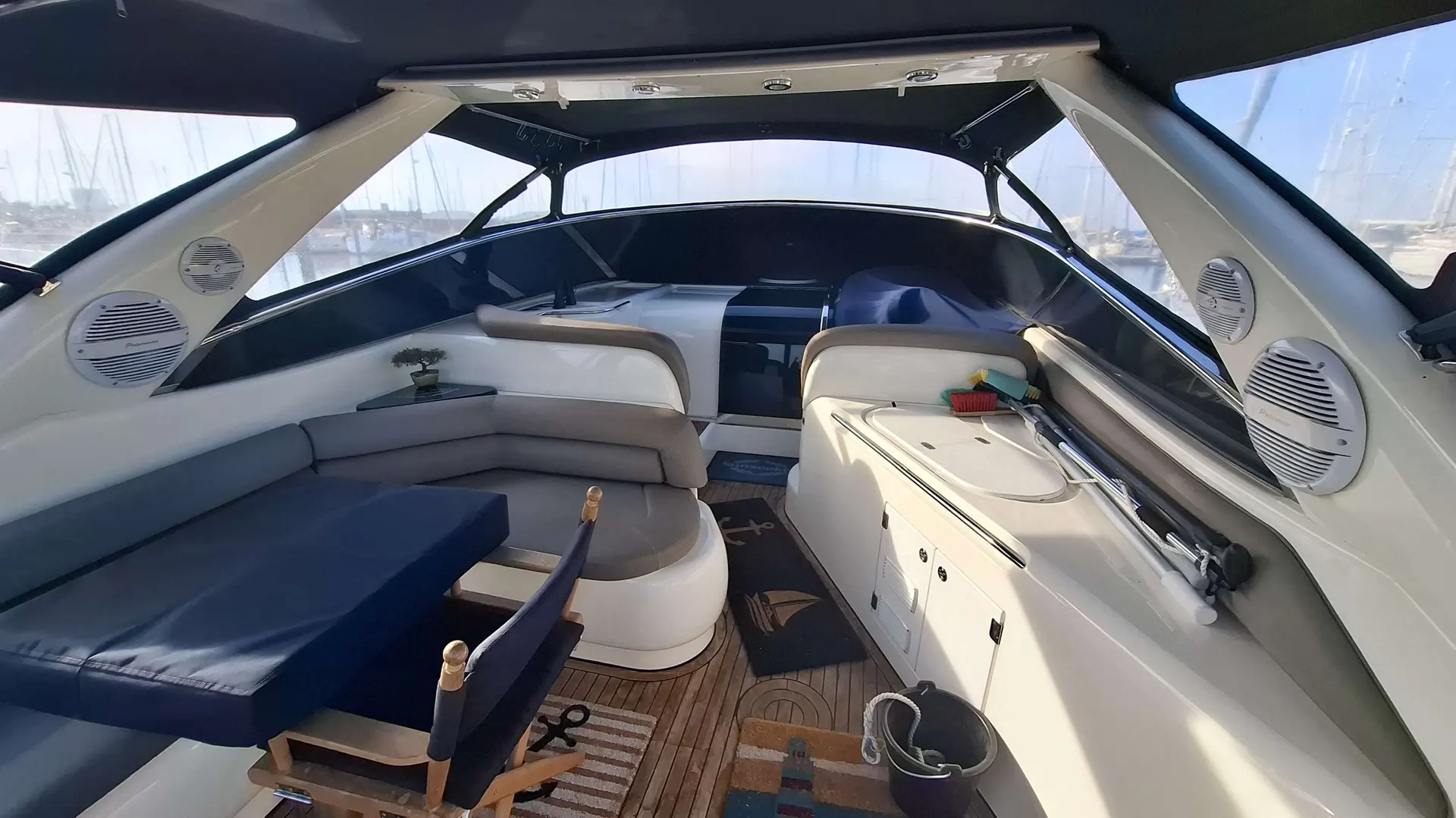 Sunseeker Portofino 400 — Vue du cockpit arrière couvert avec banquette, table et rangements.