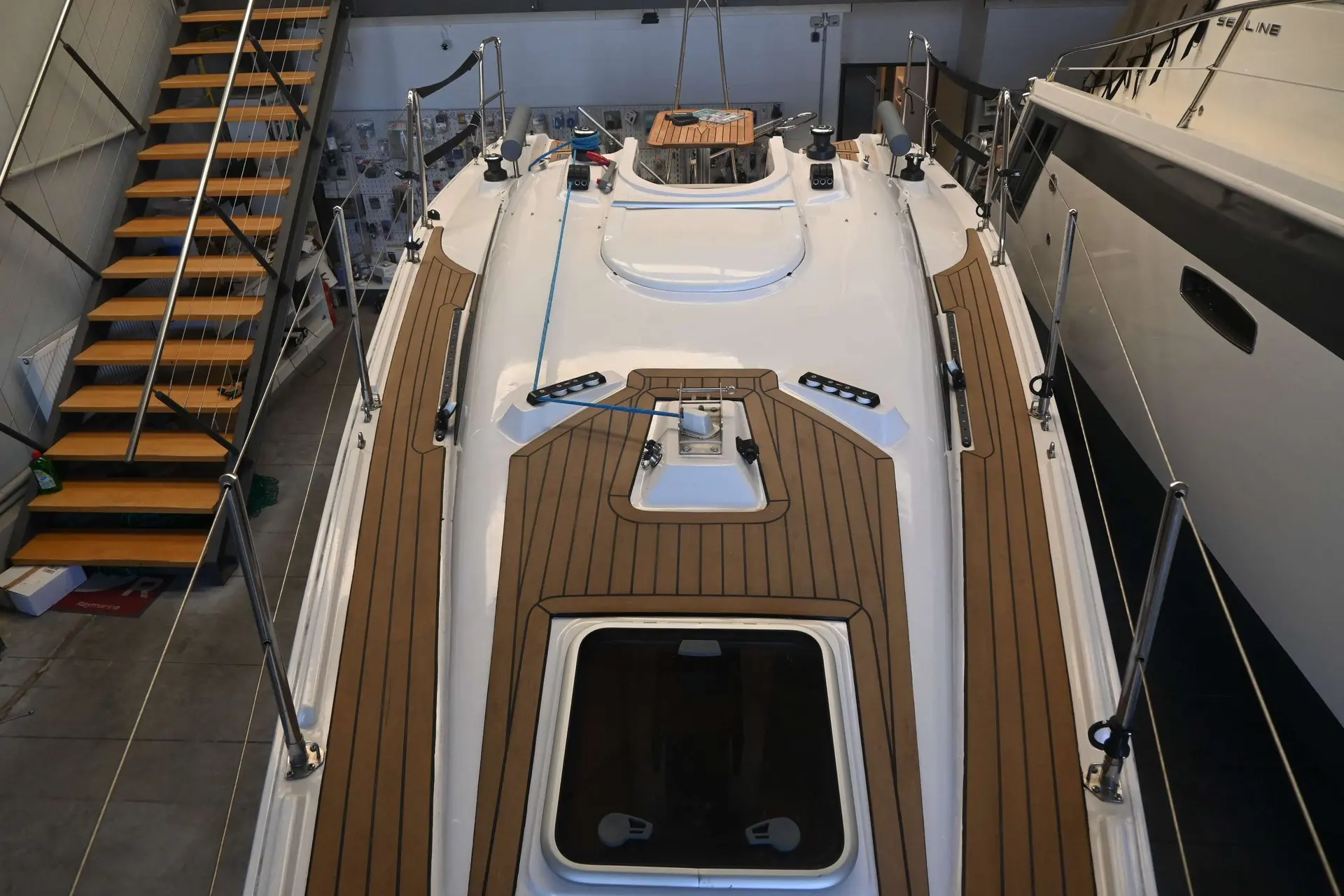 Viko Boats Viko S26 — Vue plongeante du pont et des aménagements extérieurs d’un voilier exposé en intérieur.
