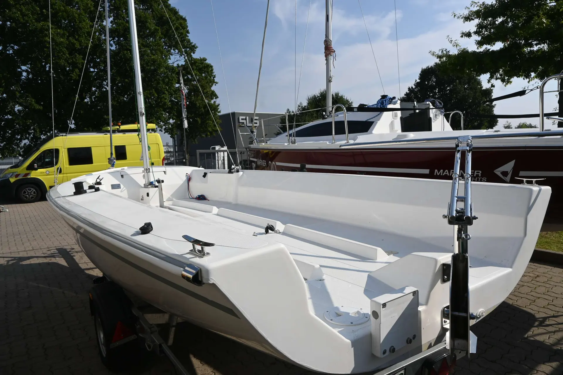 Mariner Yachts 19 — Bateau à moteur blanc ouvert, photographié sur remorque dans un espace extérieur.