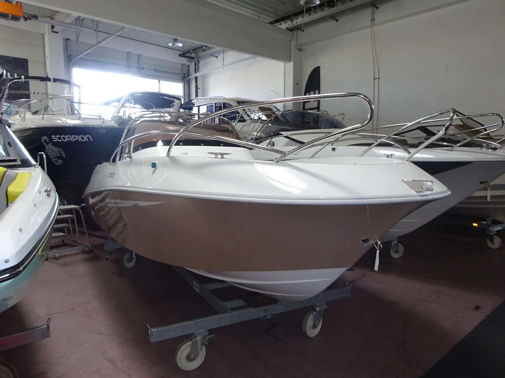 Galia 570 Sun Deck — Bateau à moteur blanc présenté sur une remorque dans un showroom.
