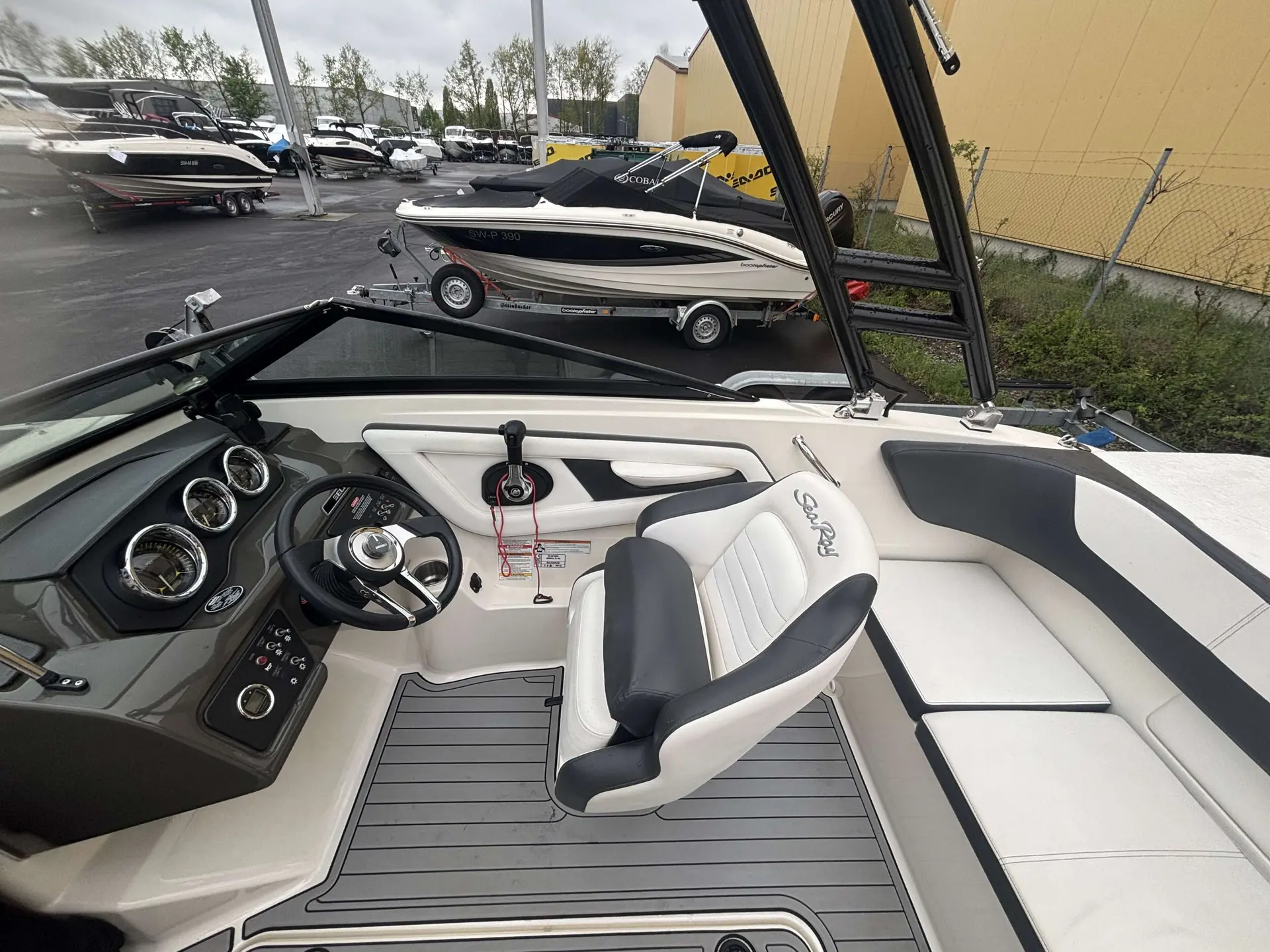 Sea Ray 190 SPXE — Vue du cockpit avec poste de pilotage, sièges et banquette avant.