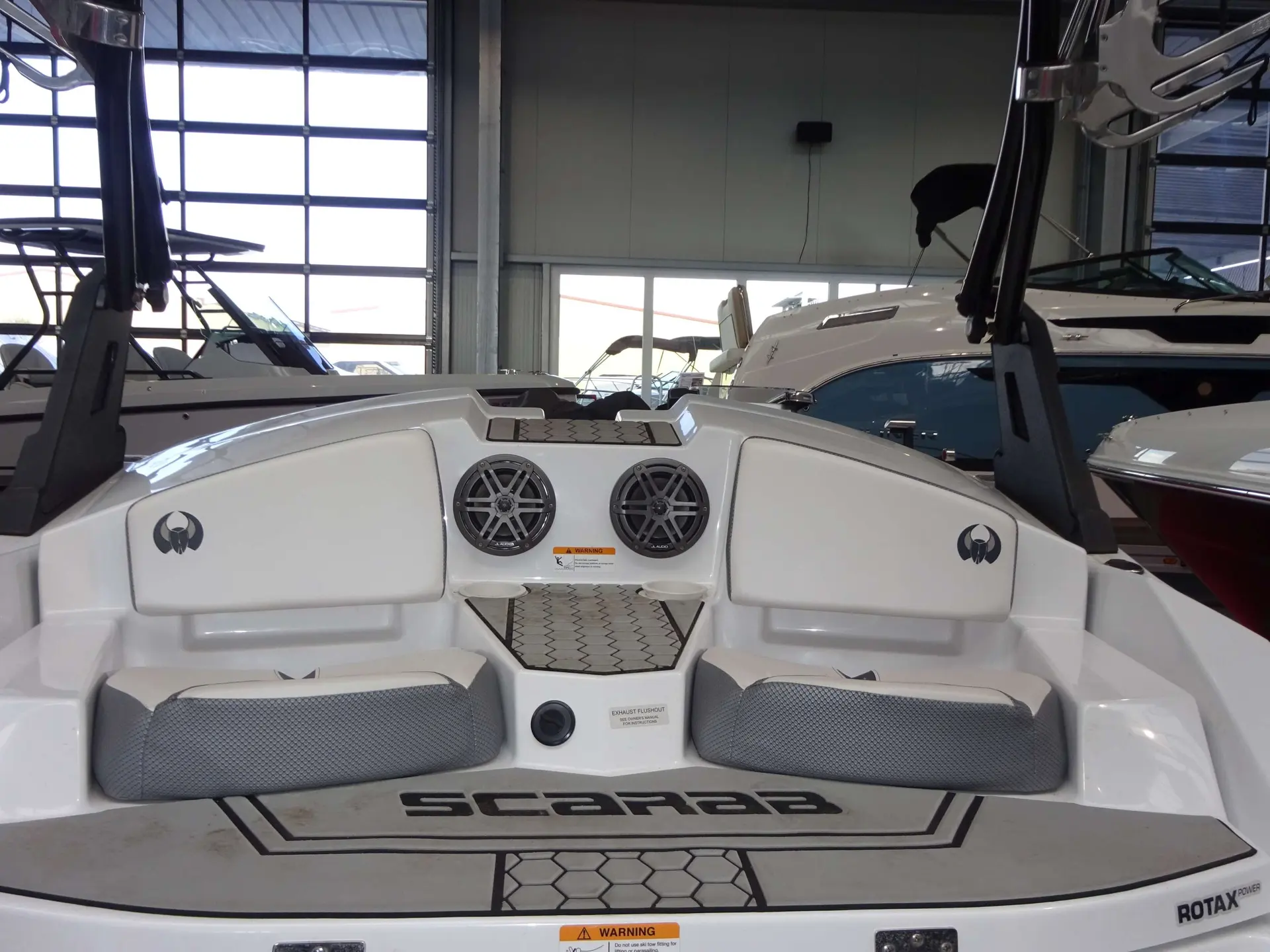 Scarab Boats Scarab 165 Gost — Vue du cockpit arrière d’un bateau, avec sièges, haut-parleurs et plateforme de bain.