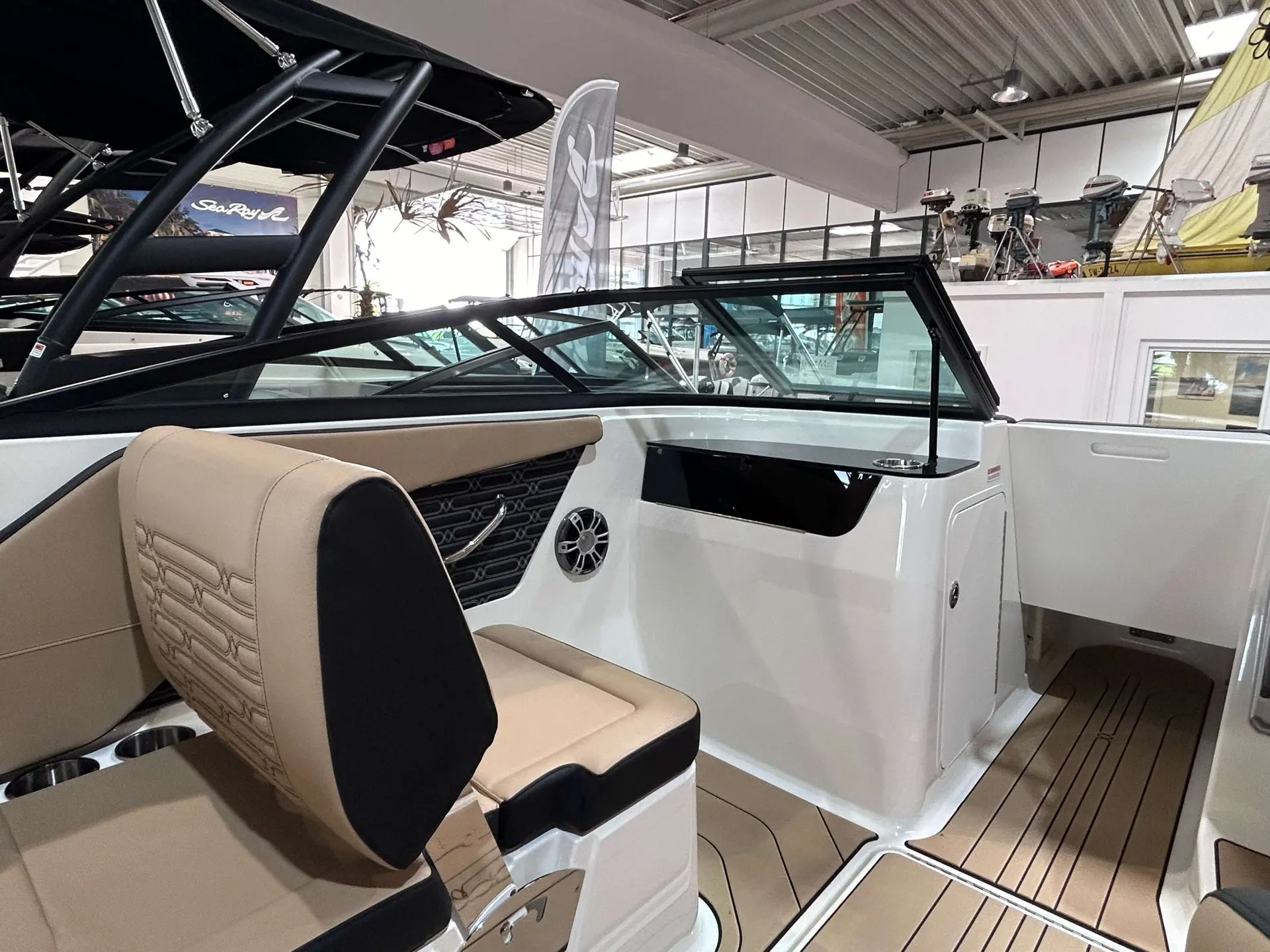 Sea Ray 190 SPXE — Vue du poste de pilotage et du cockpit d’un bateau en intérieur.