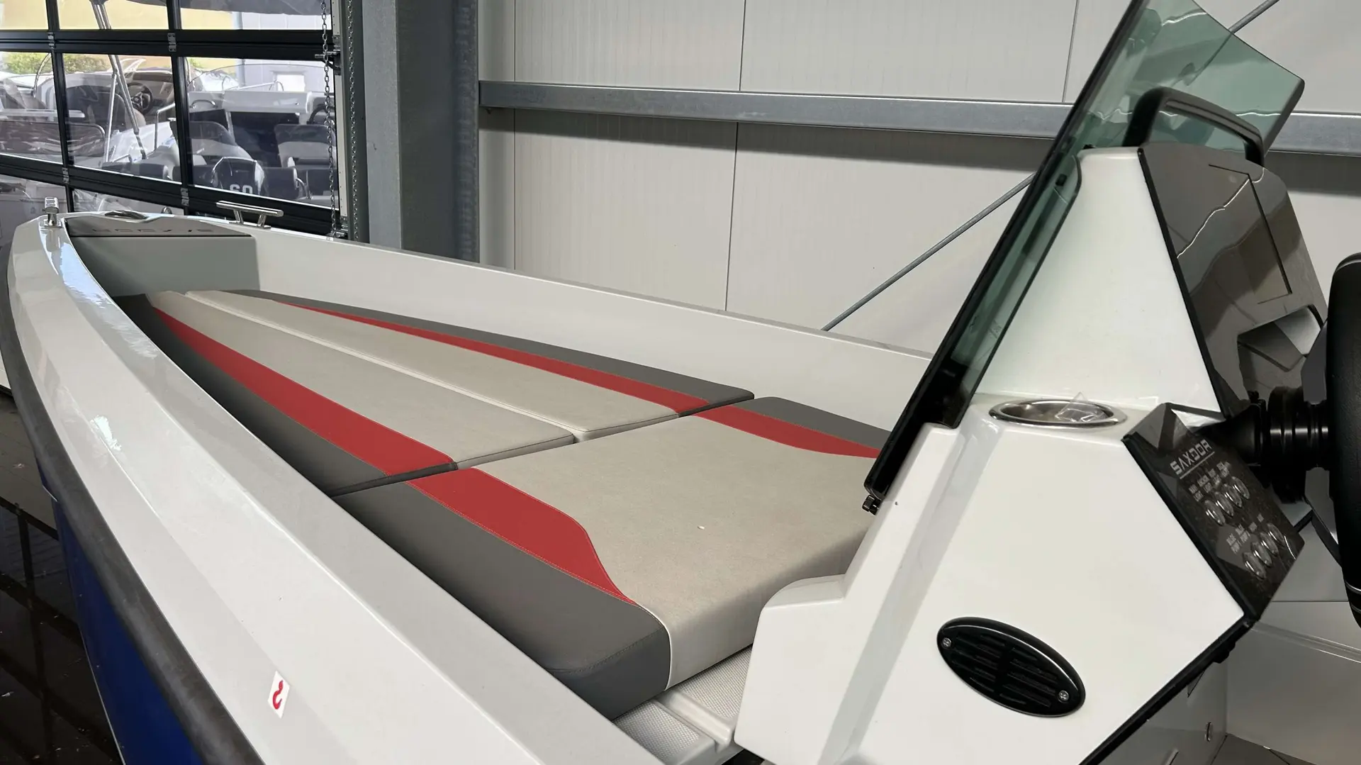 Saxdor 200 Pro Sport — Vue rapprochée de la proue et du poste de pilotage d’un bateau exposé en intérieur.