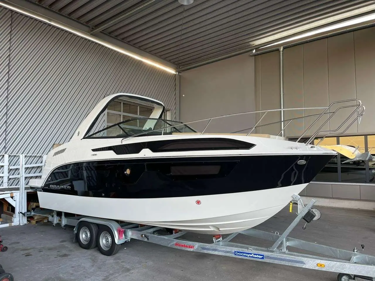 Bayliner Ciera 8 — Bateau à moteur blanc et bleu photographié de trois quarts sur sa remorque.