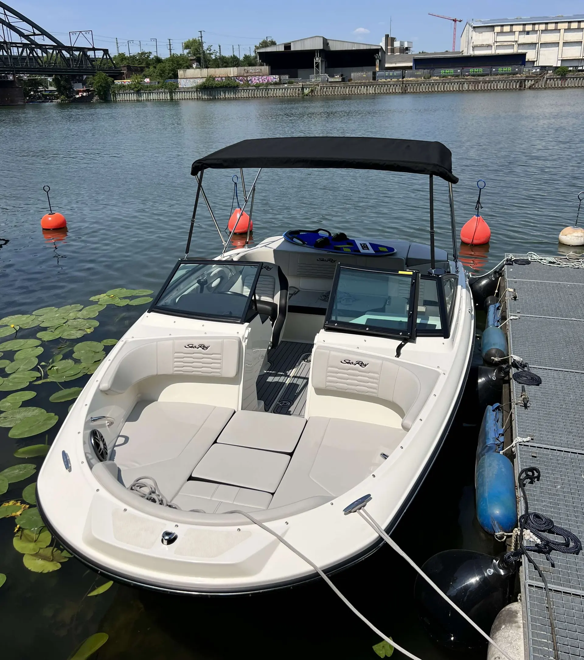 Sea Ray 190 SPXE — Bateau de plaisance blanc amarré à un ponton, vu de trois quarts depuis l'avant.