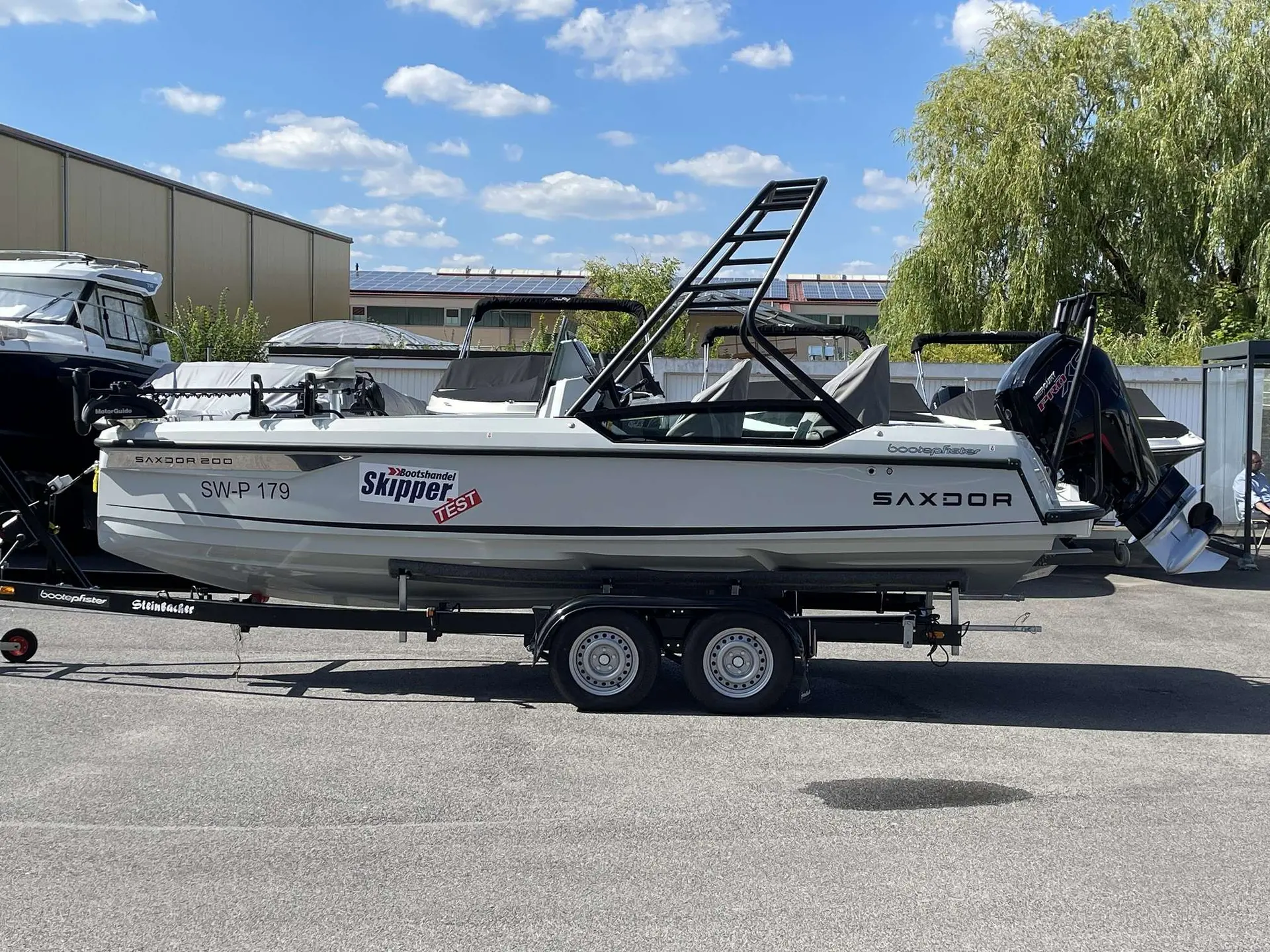 Saxdor 200 Pro Sport — Bateau Saxdor 200 vu de profil sur sa remorque, dans une zone industrielle.