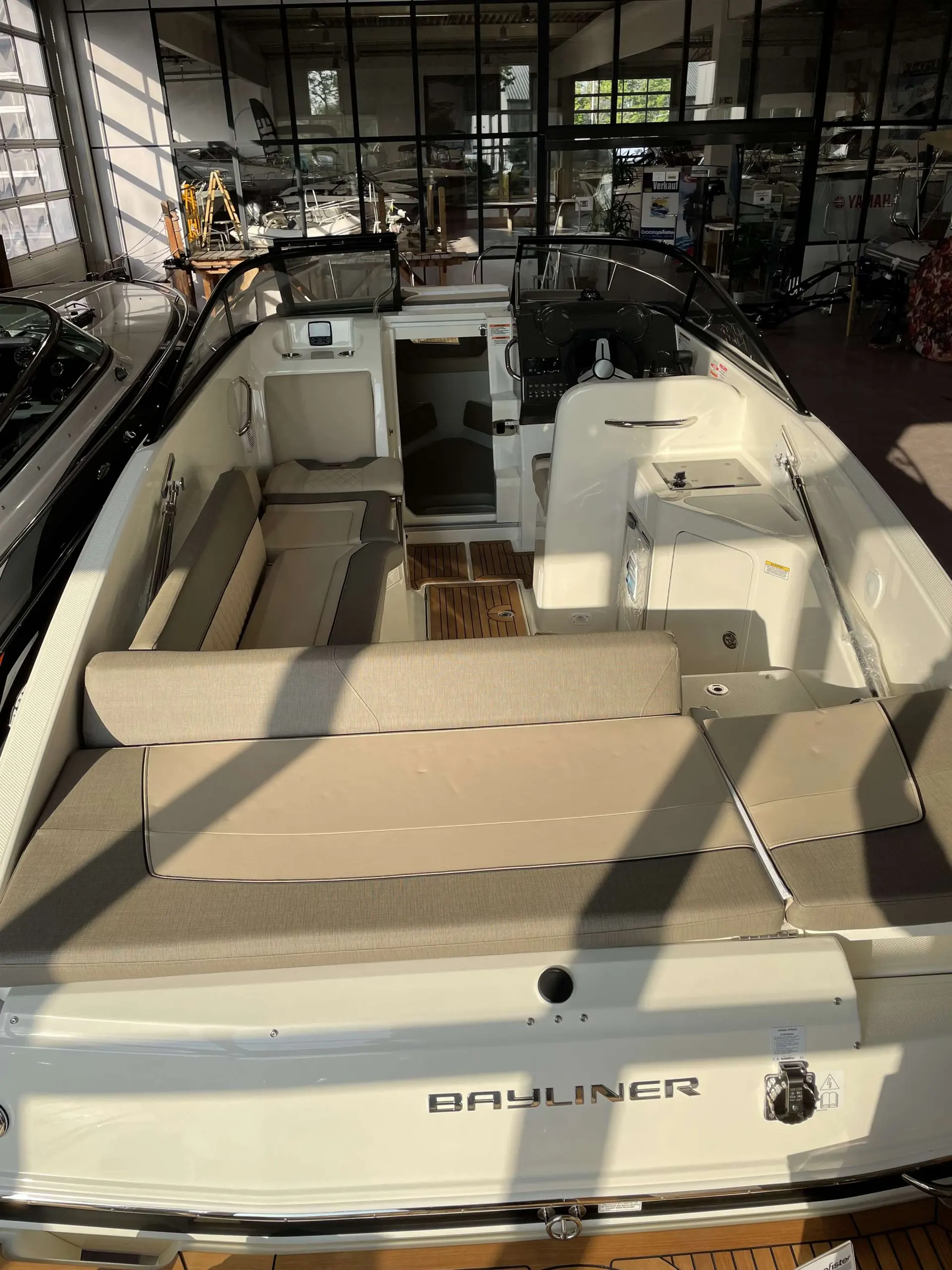 Bayliner 742 Cuddy — Cockpit ouvert d’un bateau vu depuis l’arrière, avec sièges, poste de pilotage et bain de soleil.