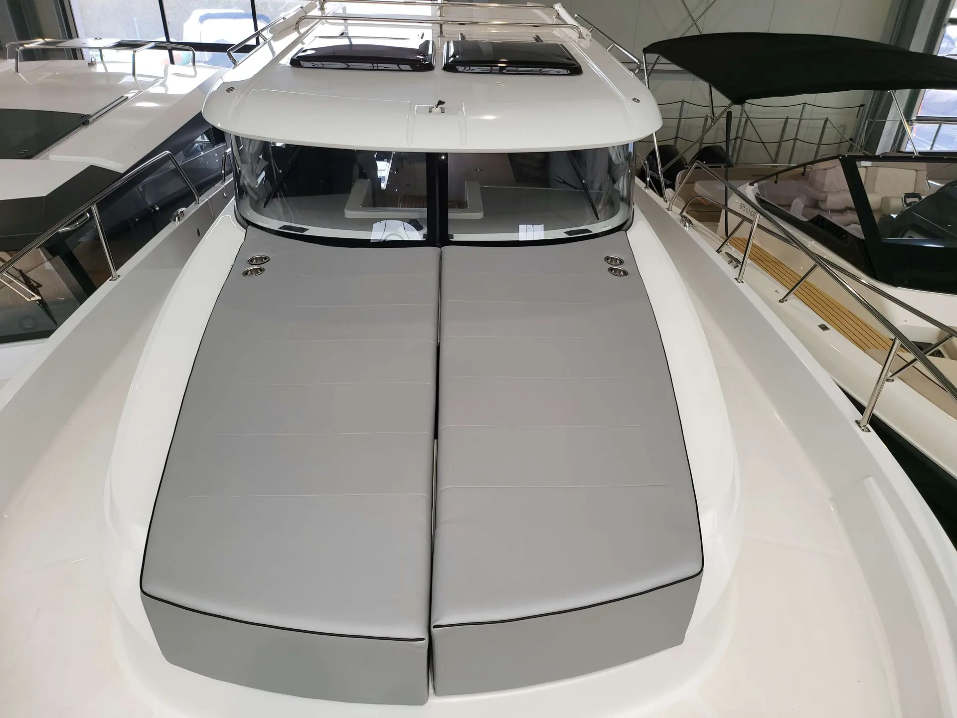 Delphia 10 Sedan — Vue de l’avant d’un bateau avec deux bains de soleil et un pare-brise.