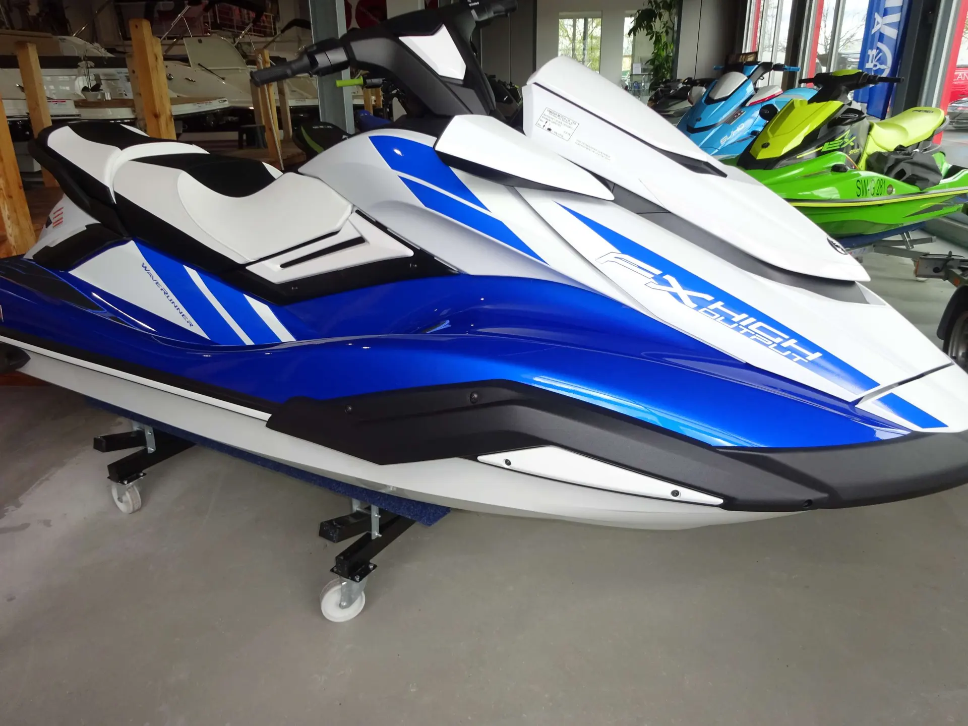 Yamaha FX HO — Un jet-ski blanc et bleu est présenté sur une remorque dans un showroom.