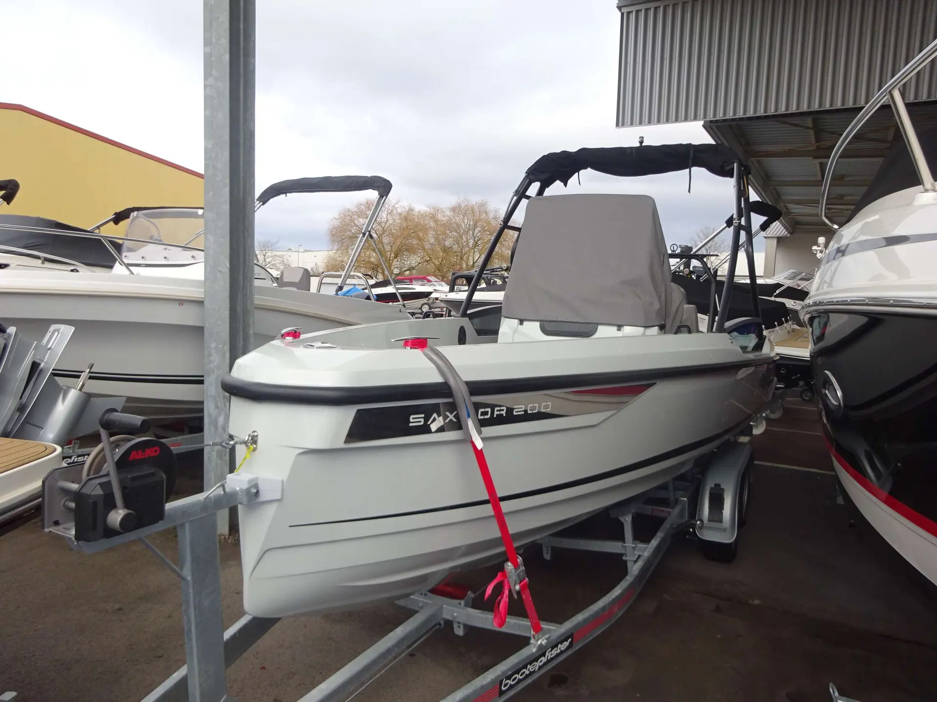 Saxdor Sport 200 — Bateau blanc présenté sur remorque dans un espace de stockage couvert.