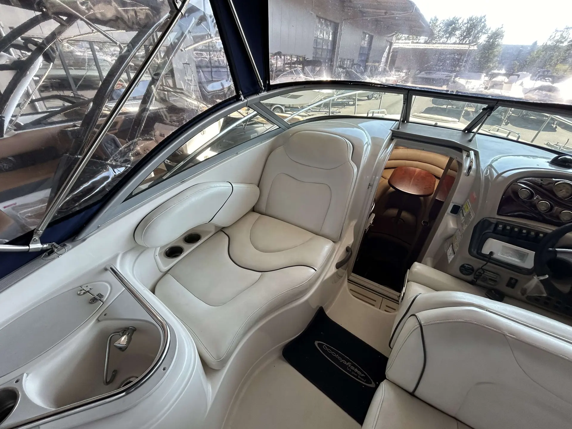 Monterey 250 — Vue intérieure du poste de pilotage et du salon avant, avec évier et sièges.