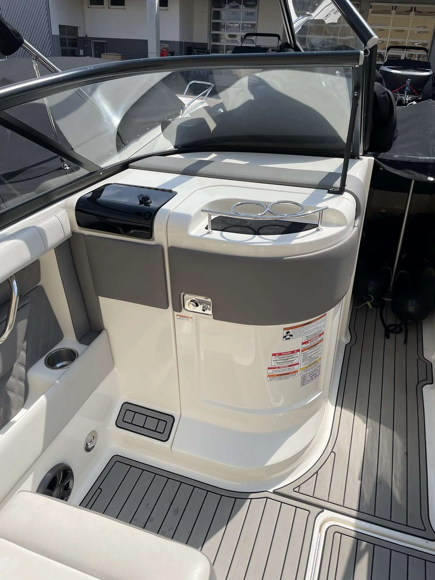 Sea Ray 250 SLX — Vue rapprochée du cockpit arrière avec banquette, pare-brise et rangements.
