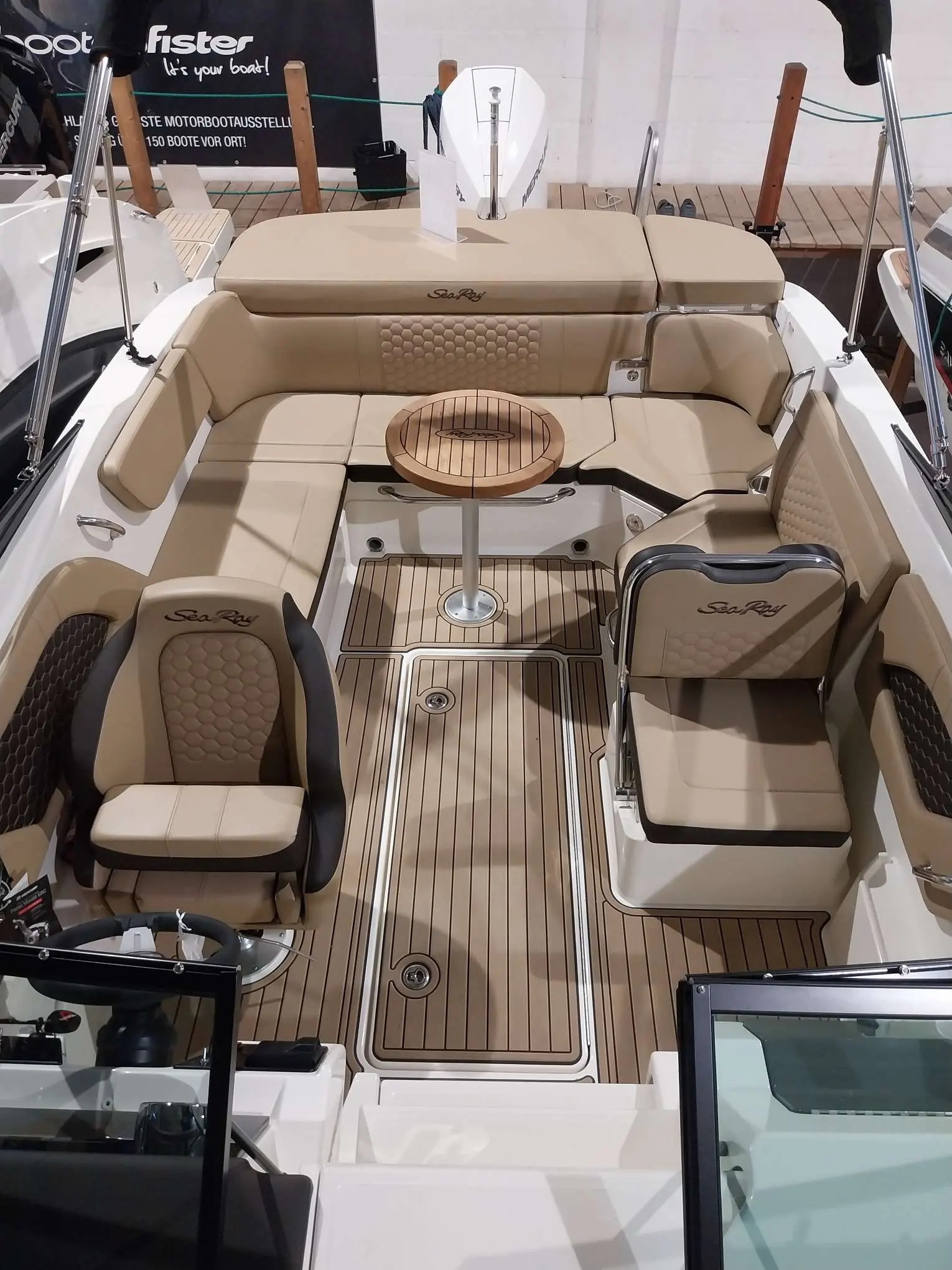 Sea Ray 230 SSOE — Cockpit aménagé avec banquettes, sièges, table et plancher imitation teck.