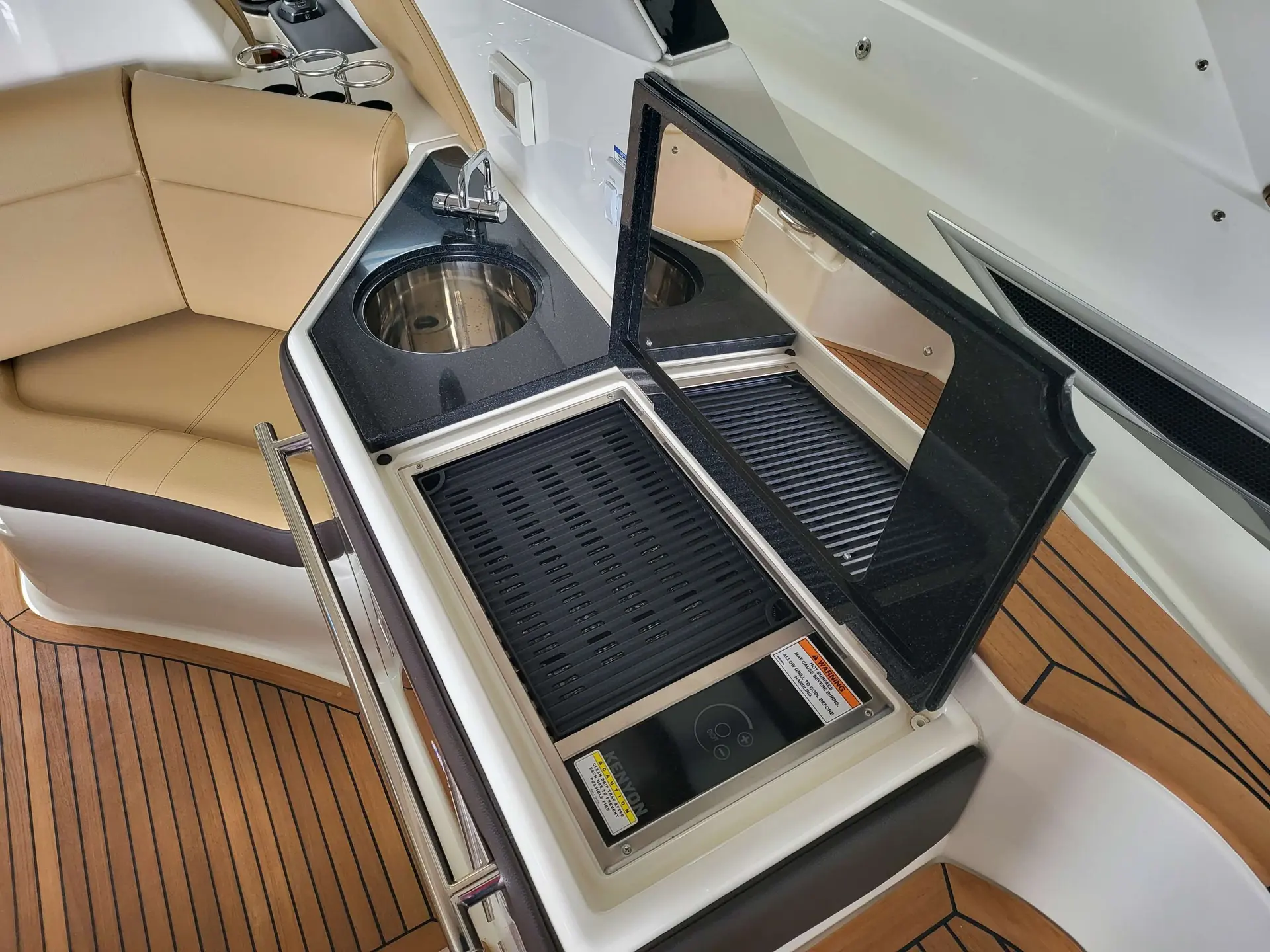Sea Ray 320 DAE — Cuisine extérieure avec évier, plaque de cuisson et assise en teck.