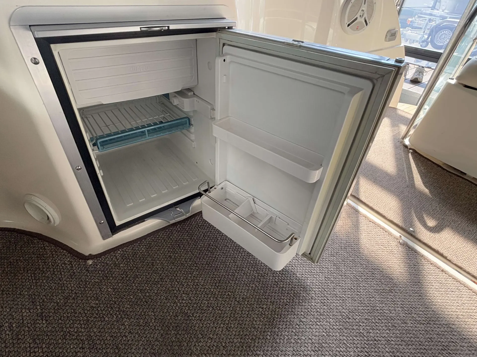 Maxum 2700 — Réfrigérateur intégré ouvert, avec ses clayettes et compartiments de porte.