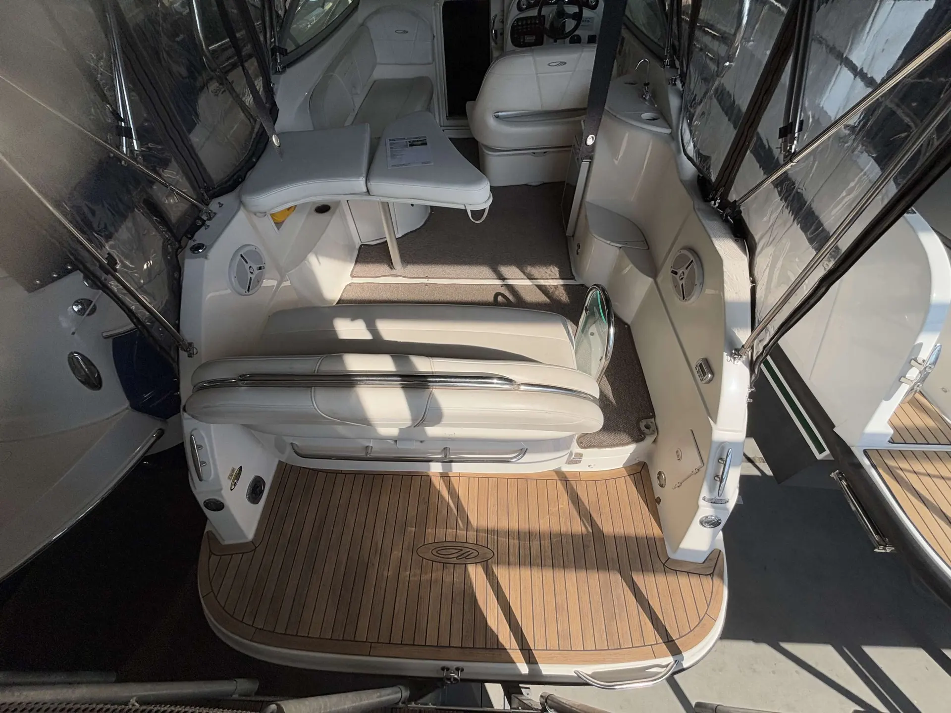 Maxum 2700 — Vue du cockpit arrière couvert avec banquettes, console de pilotage et plage arrière.