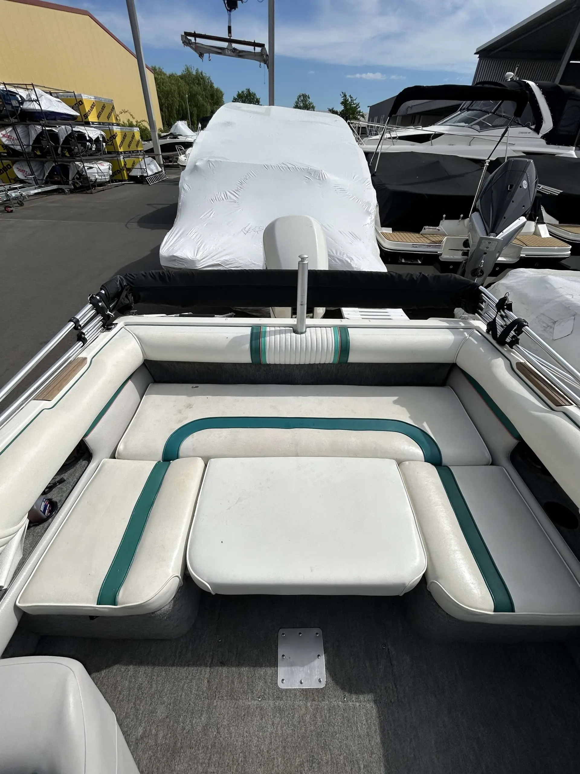 Sea Ray 190 — Vue de l'espace arrière capitonné d'un bateau couvert, photographié à quai.