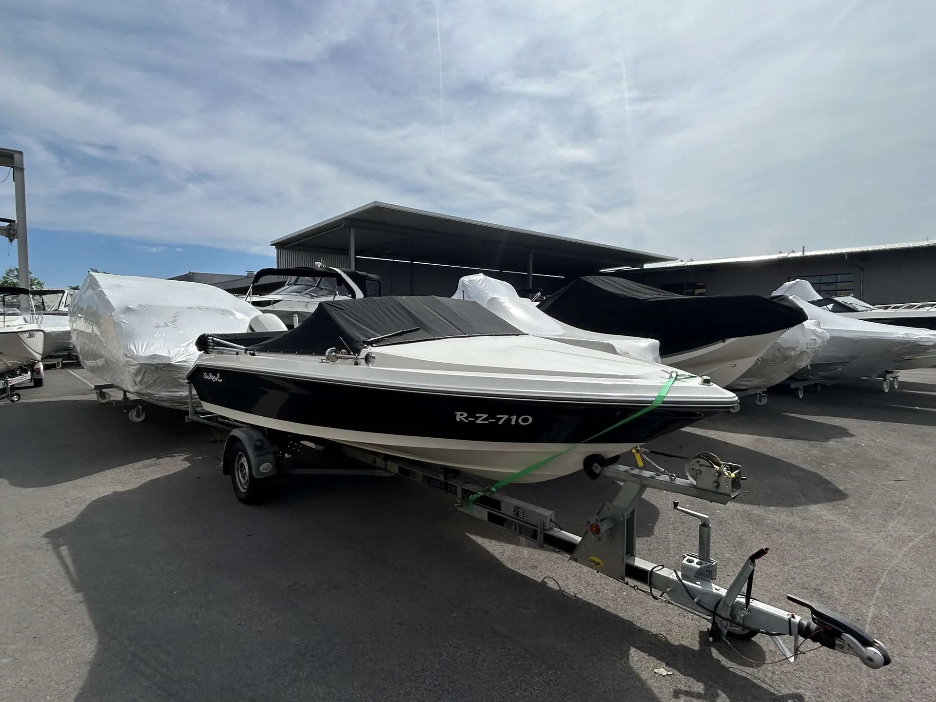 Sea Ray 190 — Bateau à moteur noir et blanc sur une remorque, dans un parc nautique.