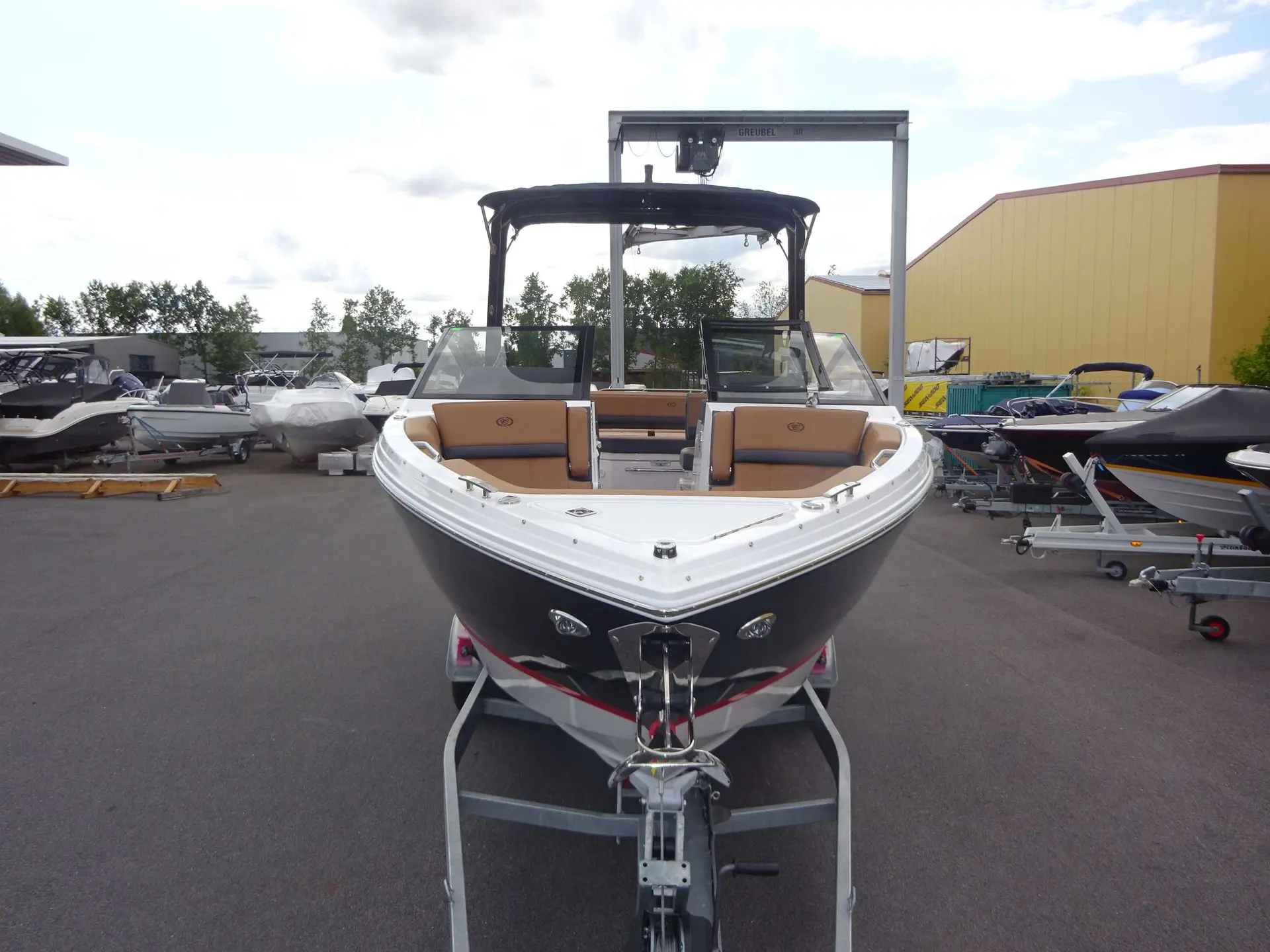 Cobalt R6 — Bateau de plaisance blanc et noir présenté sur une remorque dans un parc nautique.