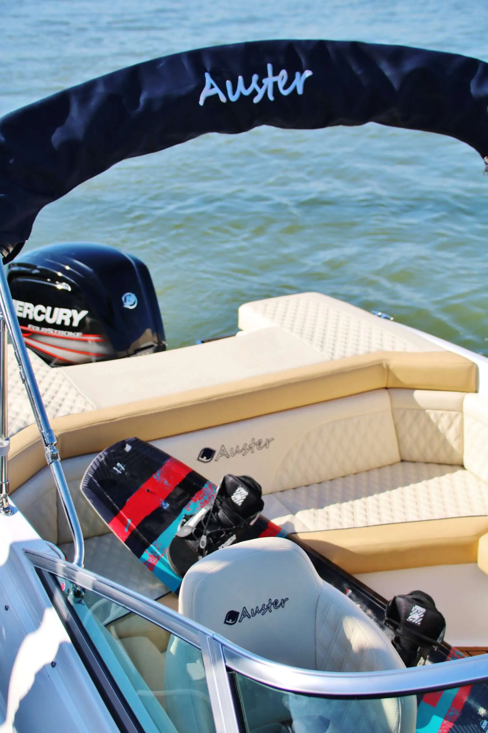 Auster 520 CD — Vue partielle du cockpit avec sellerie, moteur hors-bord et équipement nautique.
