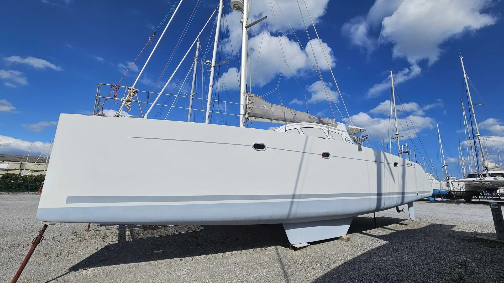 AB Marine Eclipse 472 — Voilier blanc photographié à terre, vu de profil parmi d'autres bateaux.