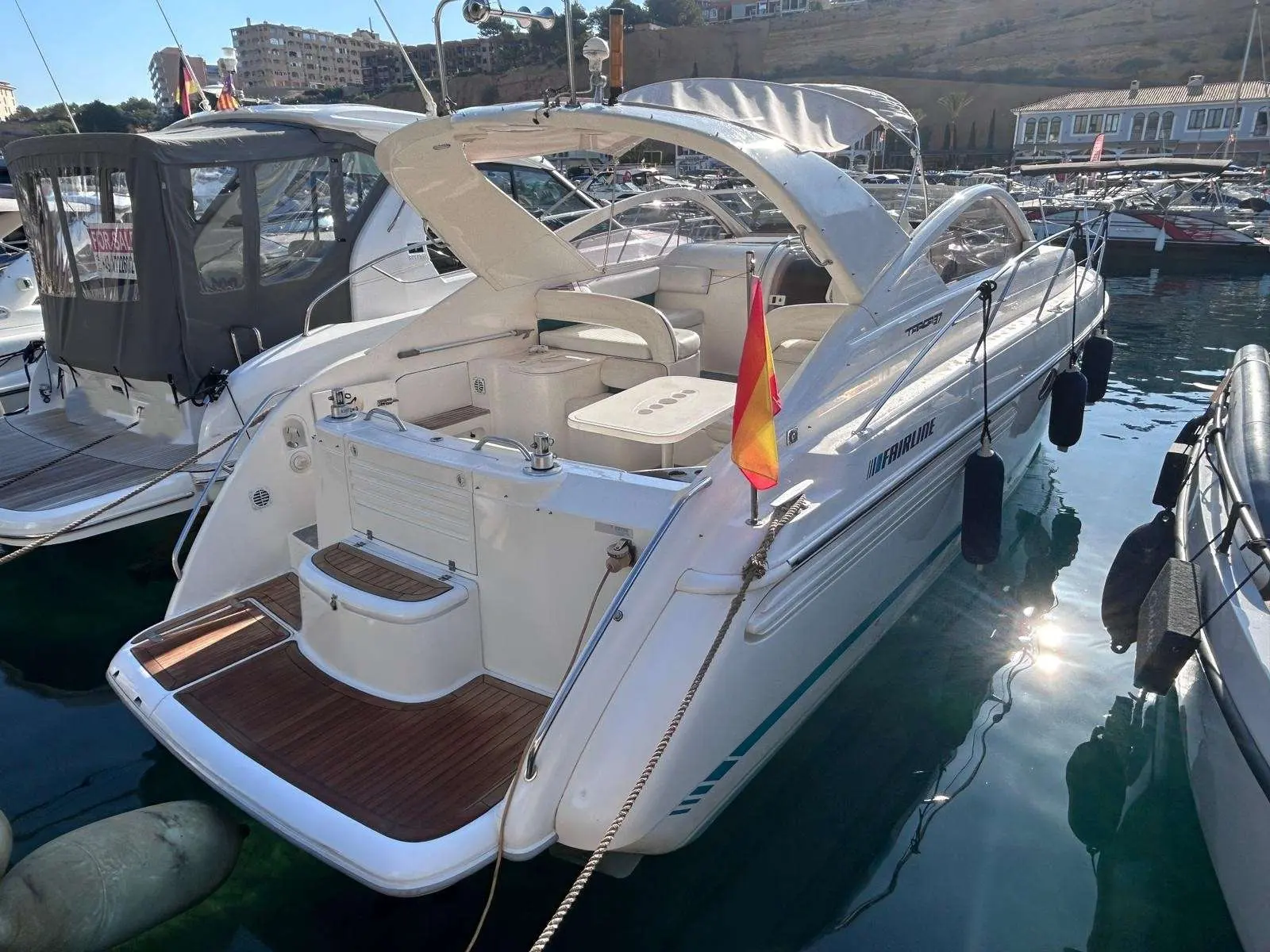 Fairline Targa 37 — Vue arrière trois-quarts d’un bateau à moteur amarré dans un port.