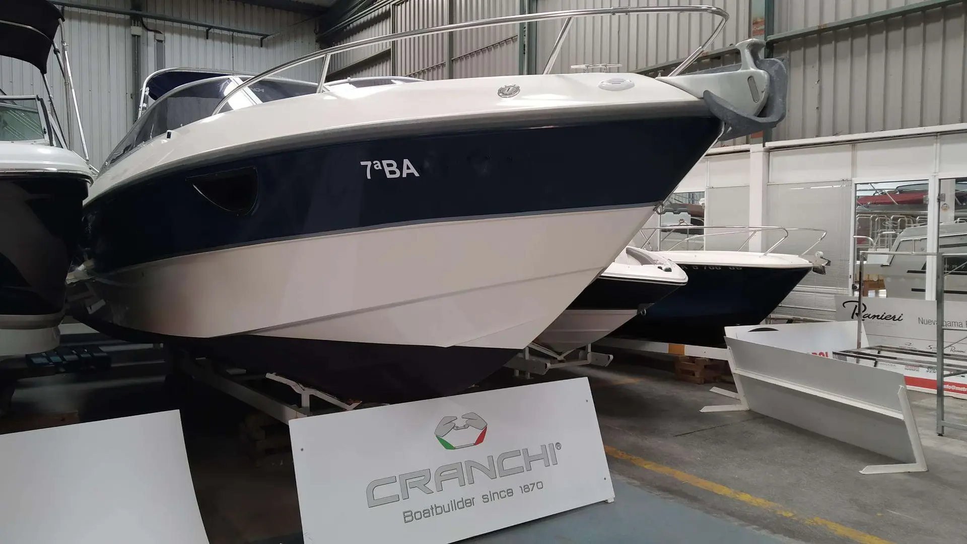 Cranchi CSL 27 — Bateau à moteur vu de trois quarts avant dans un hall d’exposition.