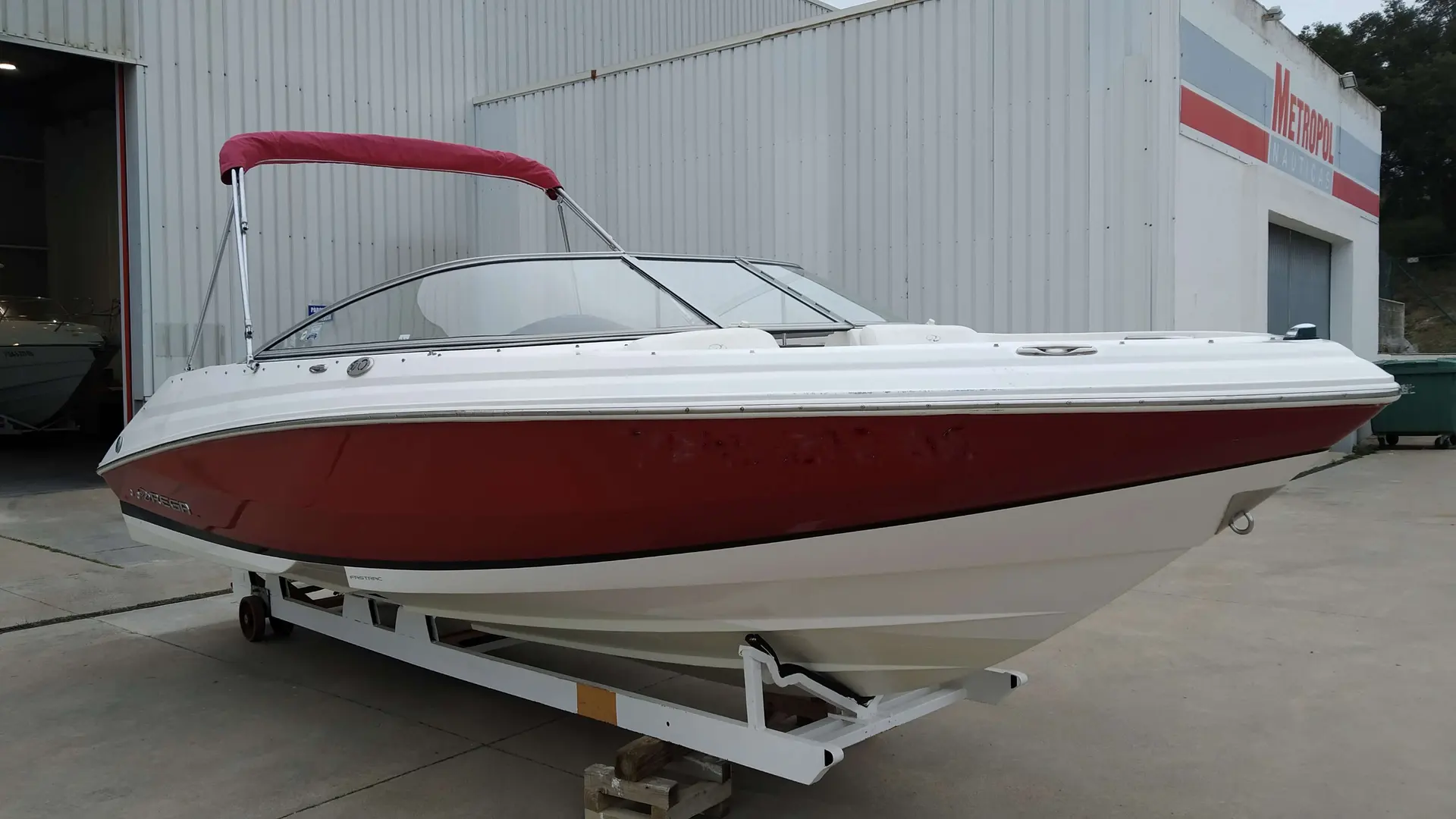 Regal 2000 — Bateau à moteur rouge et blanc présenté sur une remorque devant un hangar.