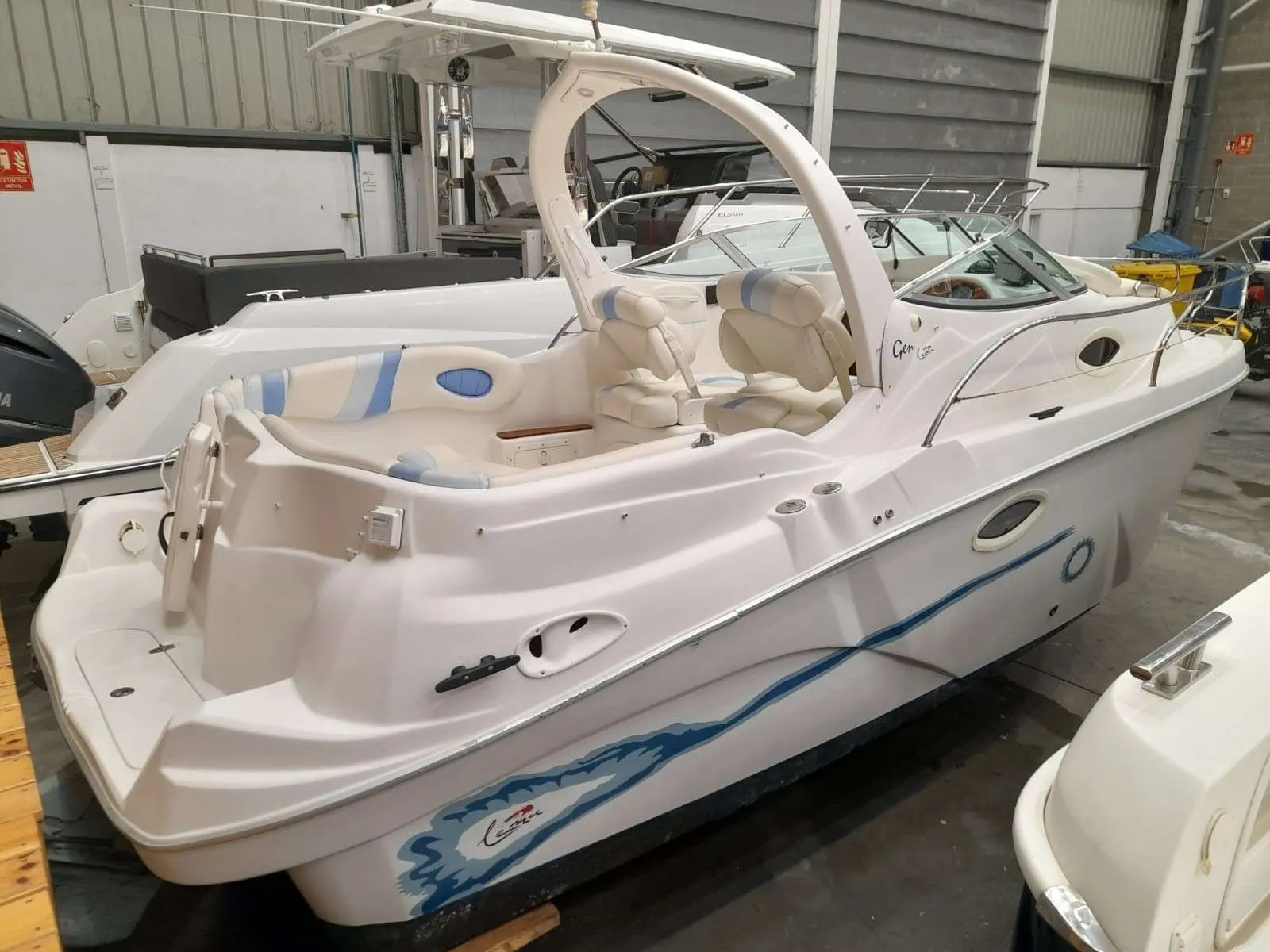 Lema Gen — Bateau à moteur blanc photographié de trois quarts arrière dans un hangar.