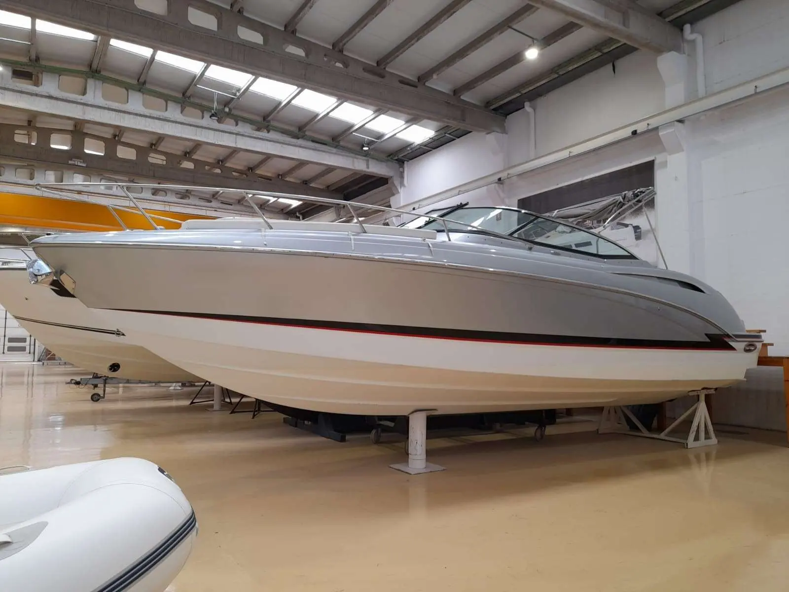 Formula 310 Sun Sport — Vue latérale d’un bateau à moteur exposé dans un hangar.