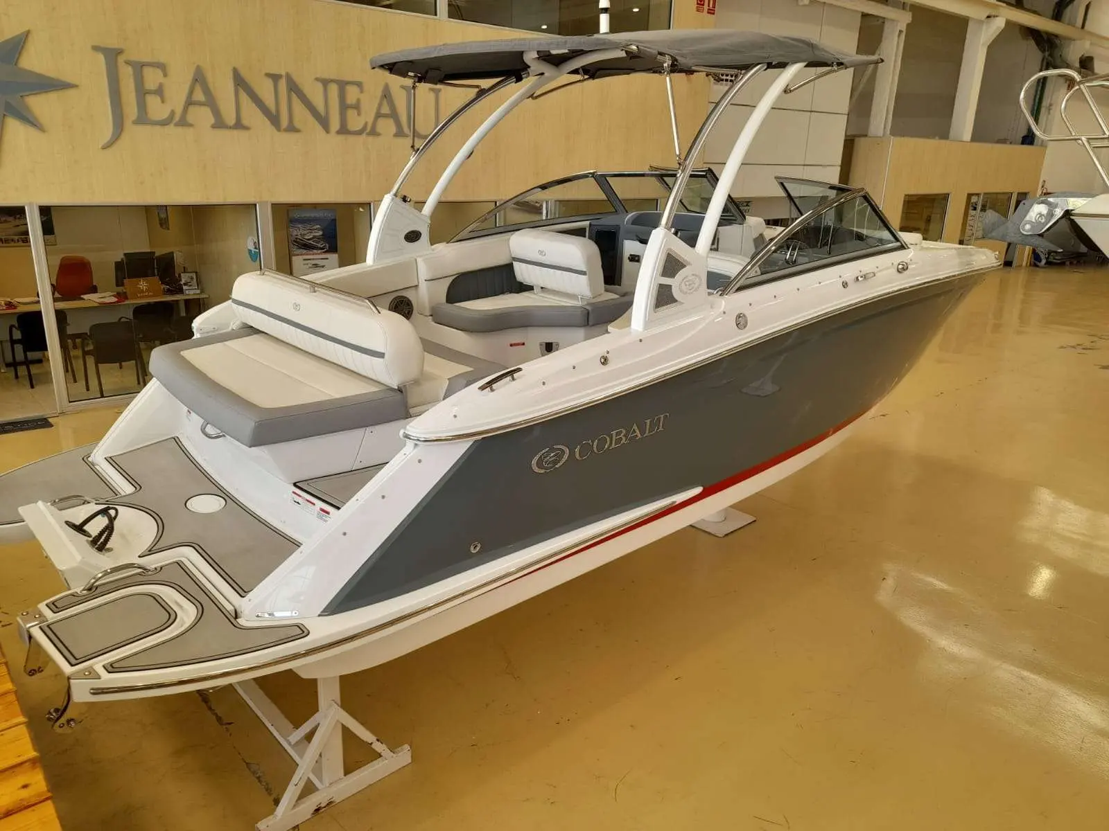 Cobalt 25 SC — Bateau à moteur blanc et gris présenté sur un support dans un showroom.
