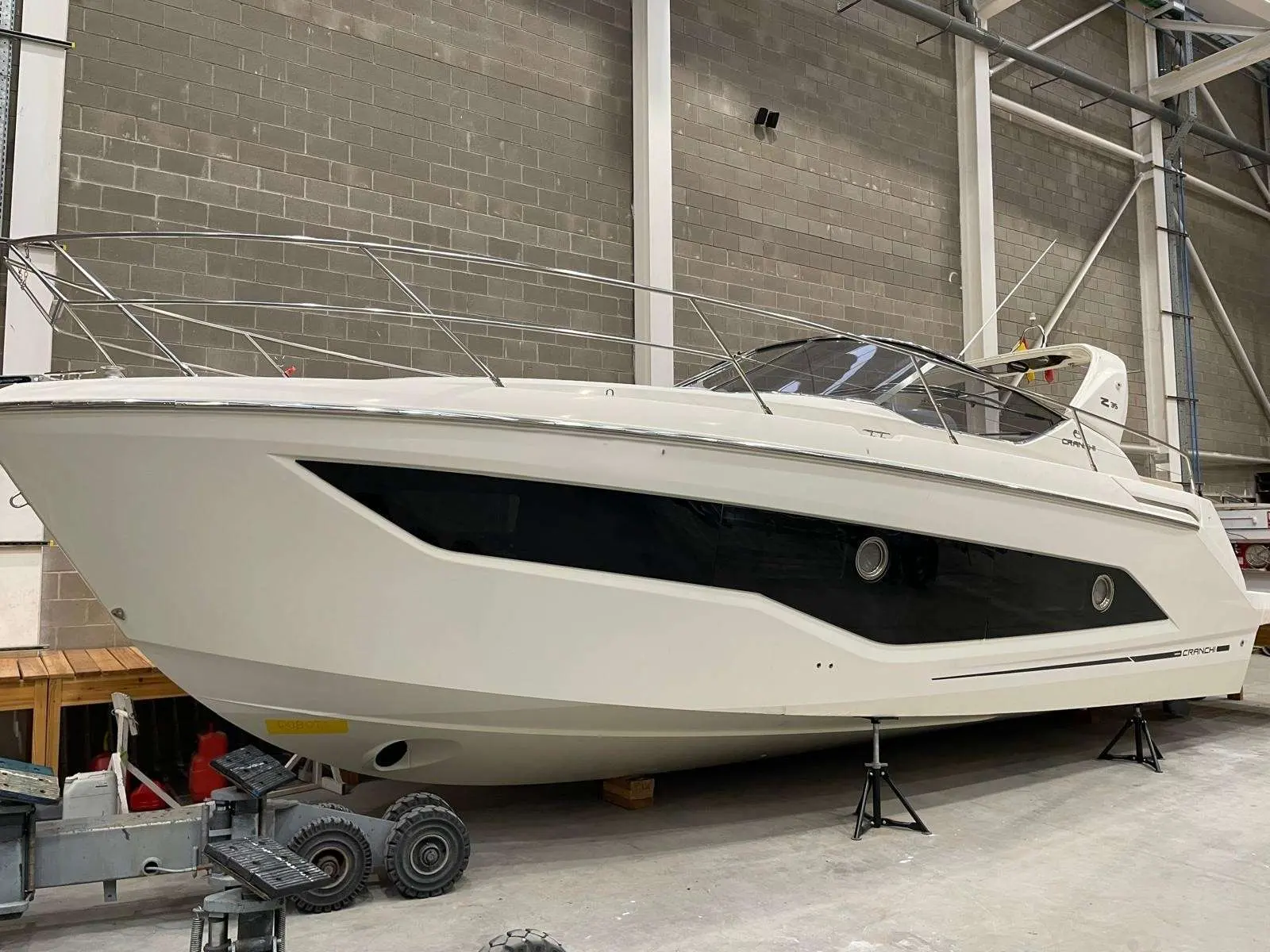 Cranchi Z 35 — Vue latérale d’un bateau blanc exposé à l’intérieur d’un hangar.