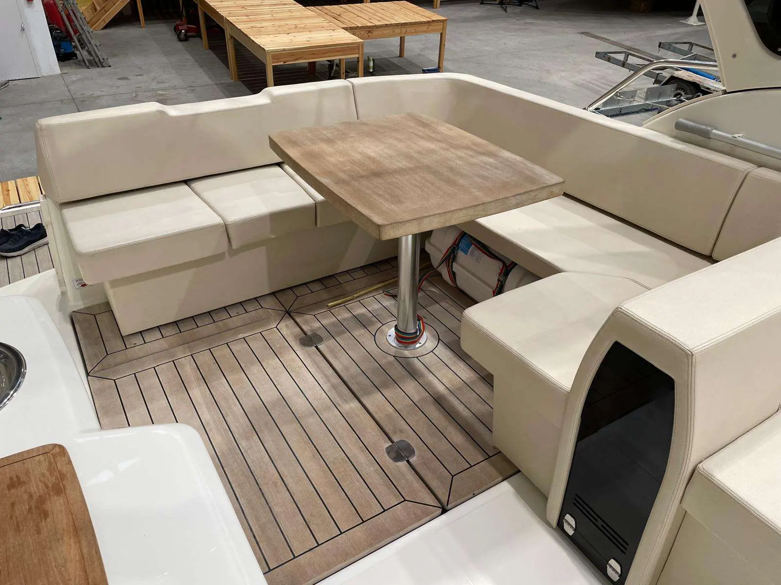 Cranchi Z 35 — Vue du cockpit avec banquettes en U, table centrale et plancher façon teck.