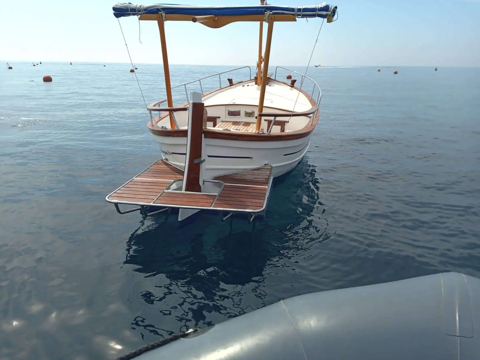 Menorquin 36 — Bateau à coque blanche amarré à un ponton flottant sur une mer calme.