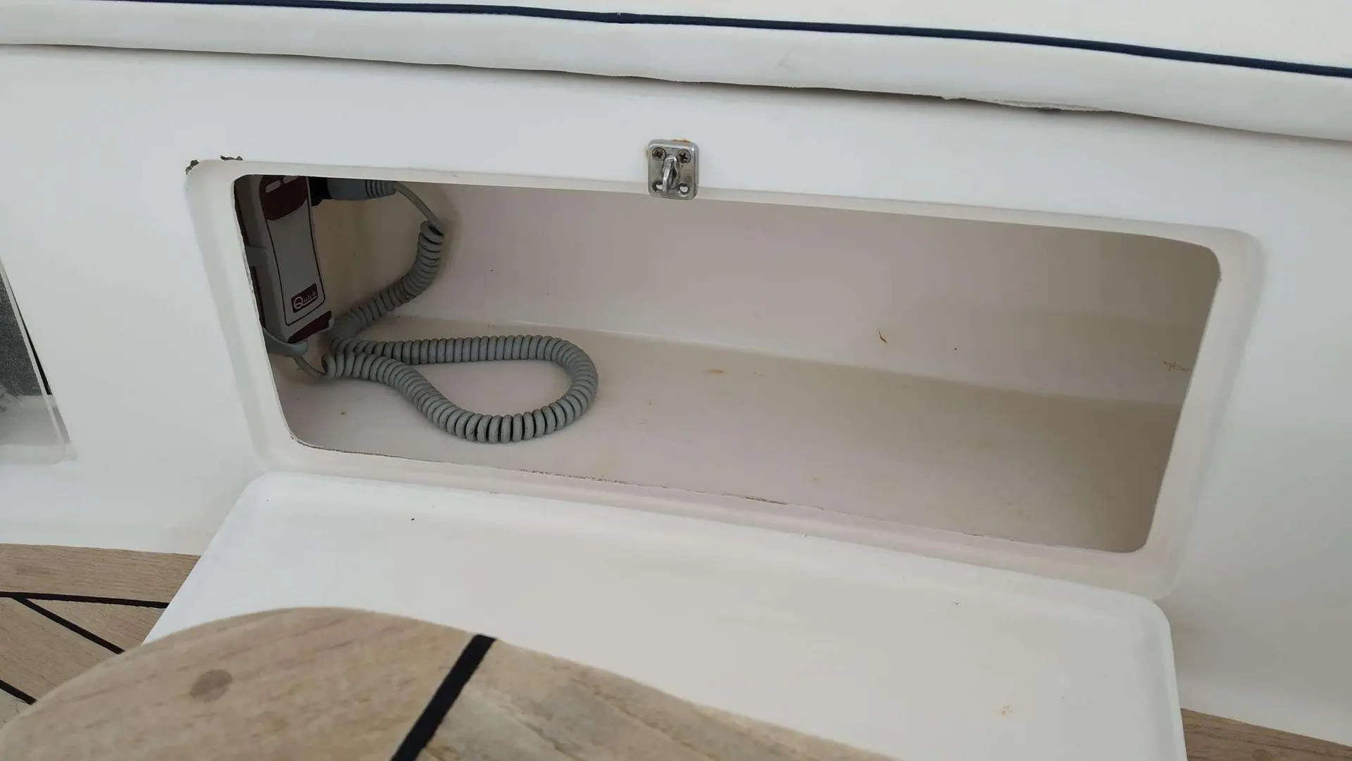 Menorquin 36 — Compartiment de rangement ouvert avec un câble spiralé à l’intérieur.