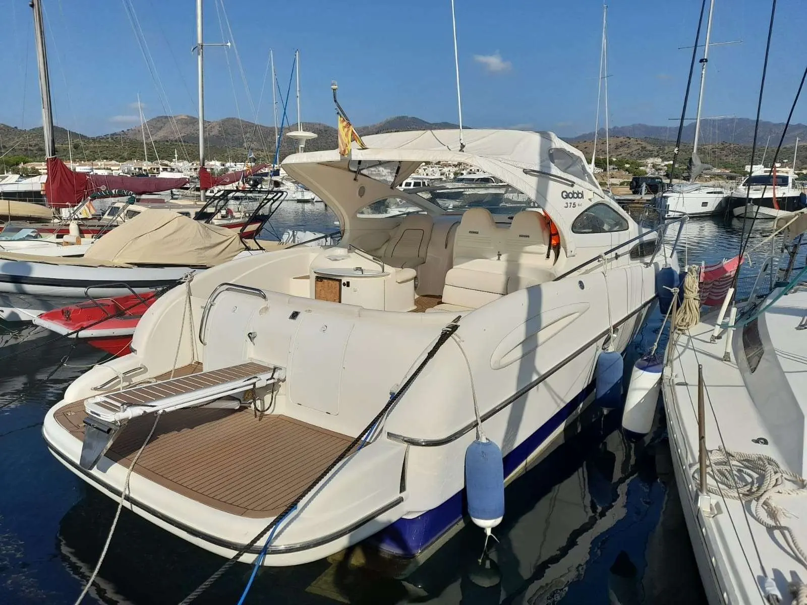Gobbi 375 SC — Bateau à moteur blanc amarré dans un port, vu de trois quarts arrière.