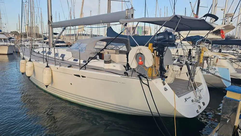 X-Yachts X-50 — Voilier blanc amarré dans une marina, vu de trois quarts arrière.